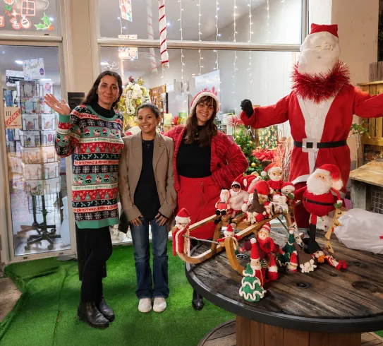Équipe festive devant les décorations de Noël de la boutique